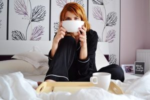 a girl drinking coffee in a bed