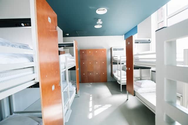 hostel room with bunk beds and lockers